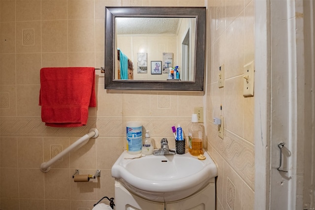 bathroom featuring vanity and tile walls