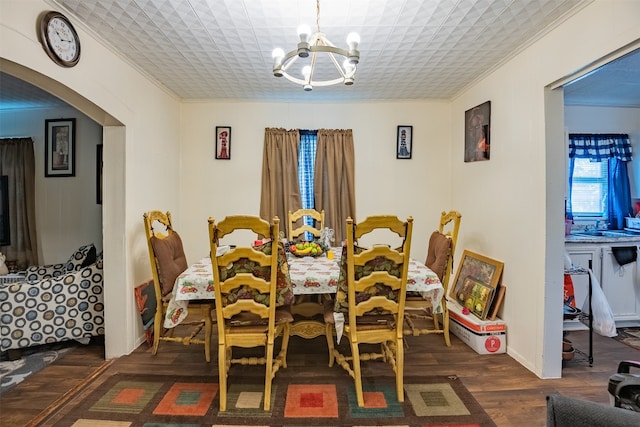 dining room with an inviting chandelier, ornamental molding, and dark hardwood / wood-style floors