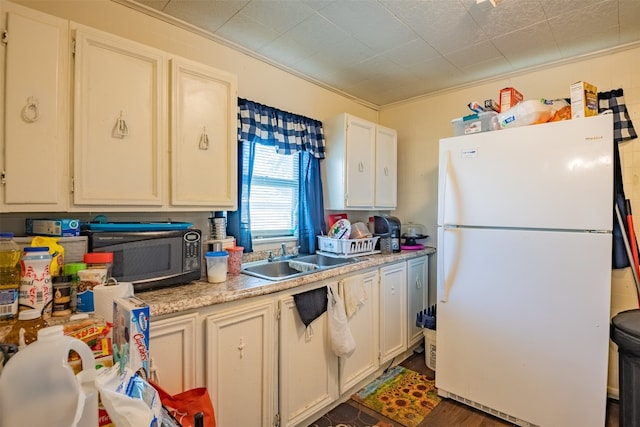 kitchen with dark hardwood / wood-style flooring, white refrigerator, white cabinets, sink, and ornamental molding