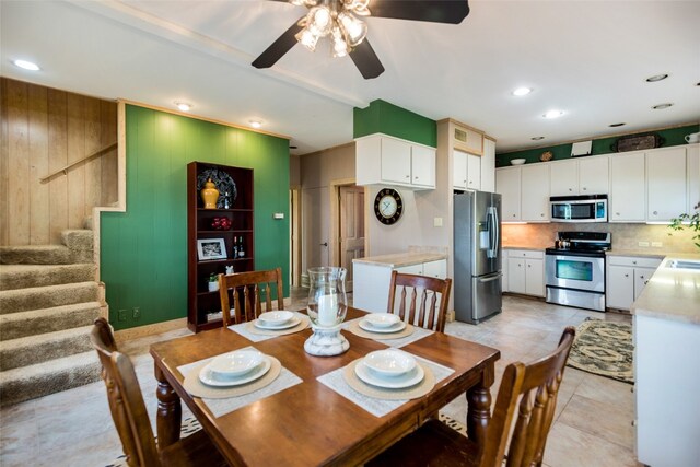 tiled dining space with ceiling fan and sink