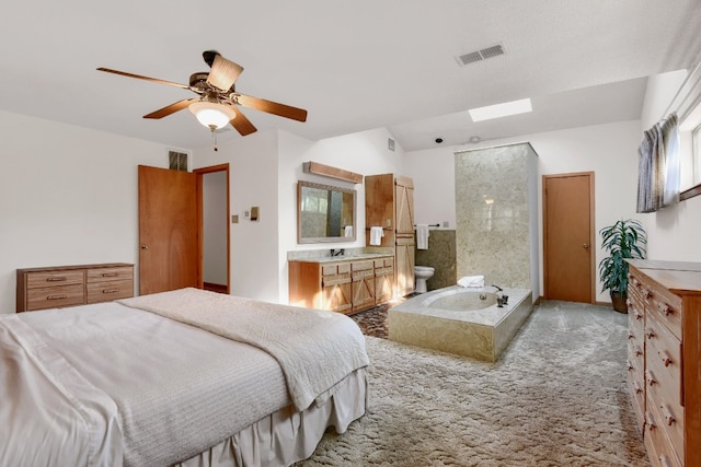 carpeted bedroom with connected bathroom, ceiling fan, and sink