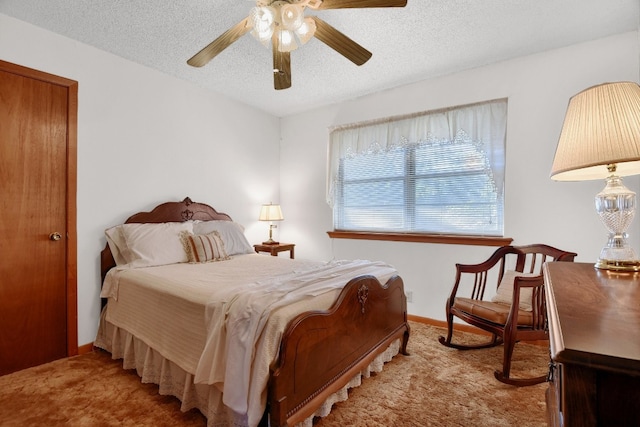 bedroom featuring light carpet, a textured ceiling, and ceiling fan