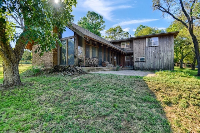 back of property featuring a yard and a patio