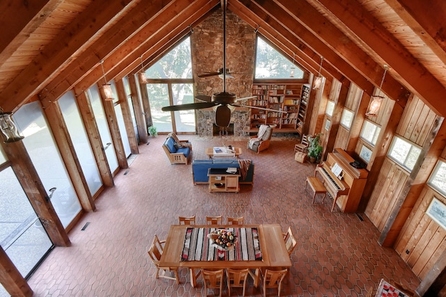 unfurnished living room featuring ceiling fan, beam ceiling, and high vaulted ceiling