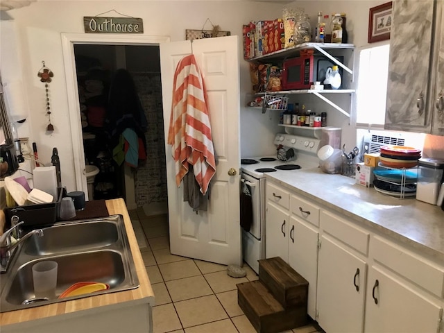 kitchen with sink, white cabinetry, electric stove, and light tile floors