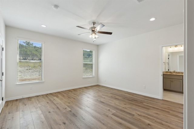 spare room featuring ceiling fan, light hardwood / wood-style floors, and plenty of natural light