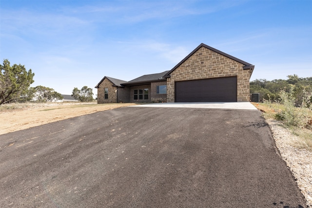 view of front of house with central AC unit and a garage