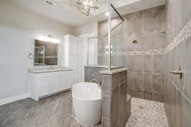 bathroom featuring a notable chandelier, vanity, and separate shower and tub