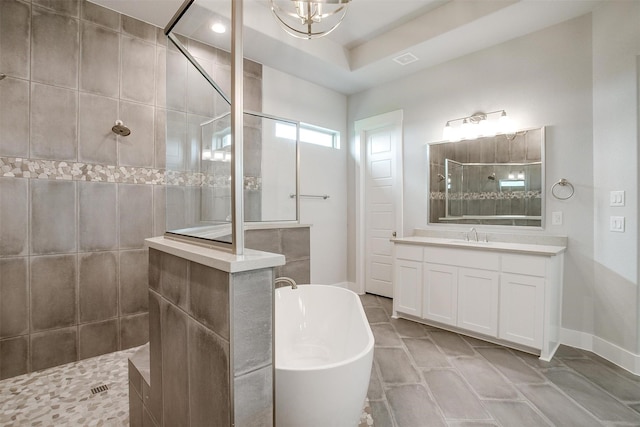 bathroom with tile patterned floors, vanity, plus walk in shower, and an inviting chandelier