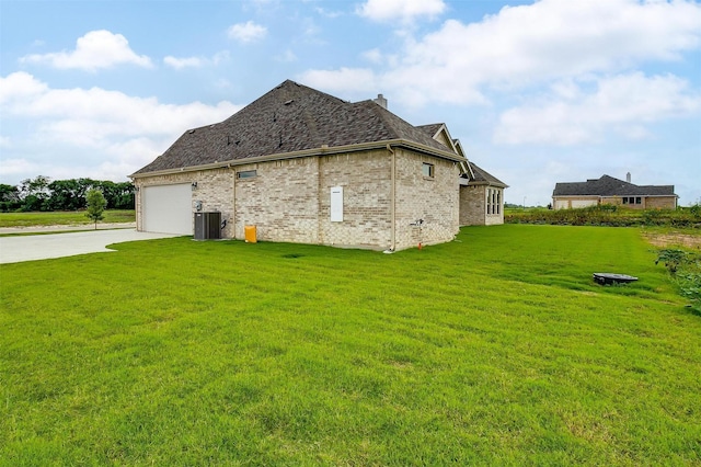 view of side of property featuring central AC, a garage, and a lawn