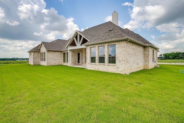 back of property featuring a patio and a lawn