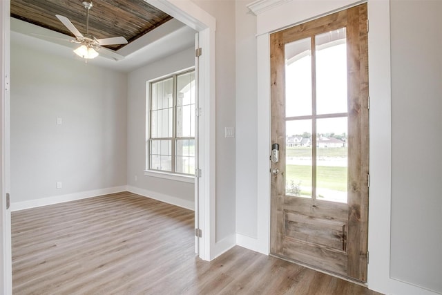 foyer with a raised ceiling, ceiling fan, light hardwood / wood-style flooring, and wood ceiling