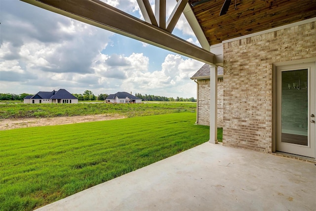 view of yard featuring ceiling fan and a patio