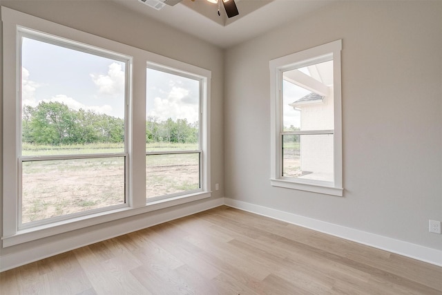 empty room featuring light hardwood / wood-style flooring, a wealth of natural light, and ceiling fan