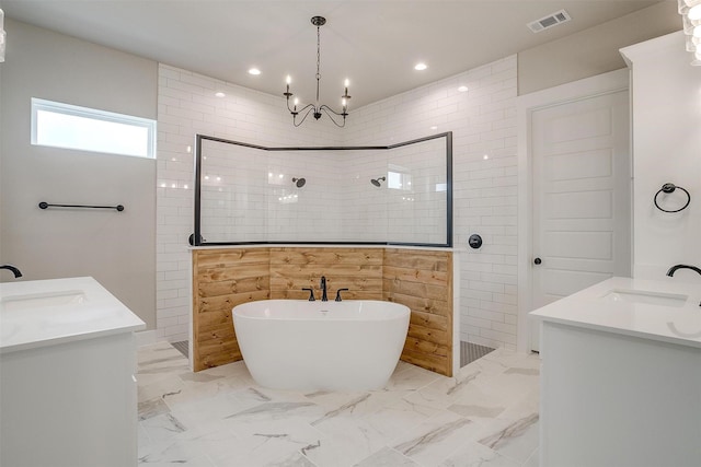 bathroom featuring shower with separate bathtub, vanity, and a notable chandelier