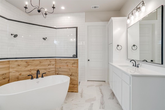 bathroom featuring vanity, independent shower and bath, and an inviting chandelier