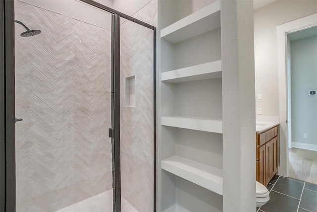 bathroom featuring an enclosed shower, vanity, built in features, tile patterned flooring, and toilet