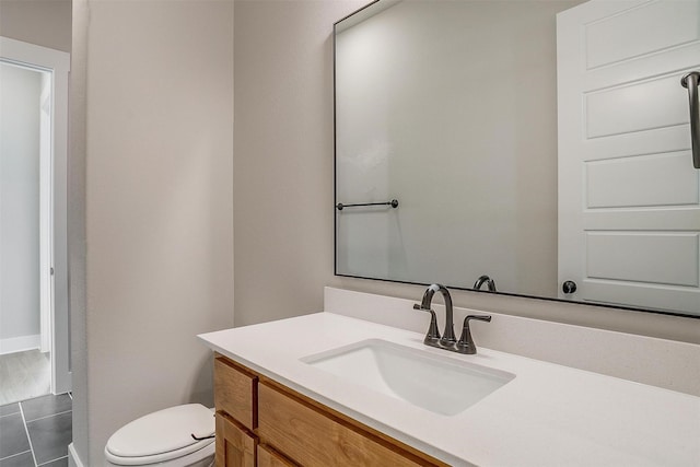 bathroom featuring tile patterned flooring, vanity, and toilet