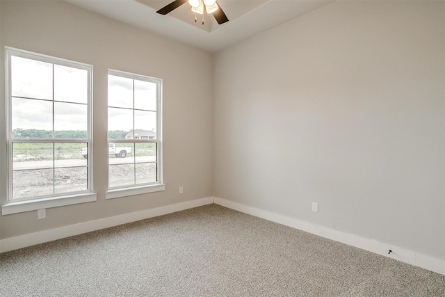 carpeted empty room featuring ceiling fan and plenty of natural light