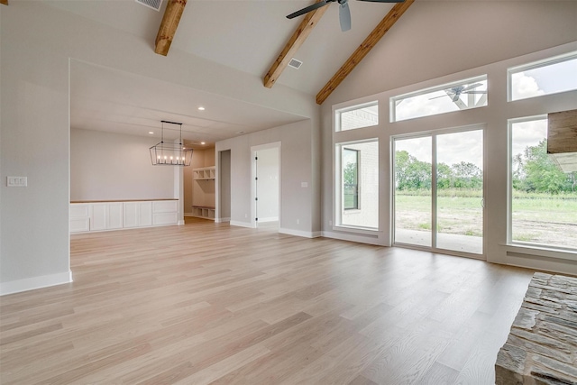 unfurnished living room with a wealth of natural light, beam ceiling, light wood-type flooring, and high vaulted ceiling