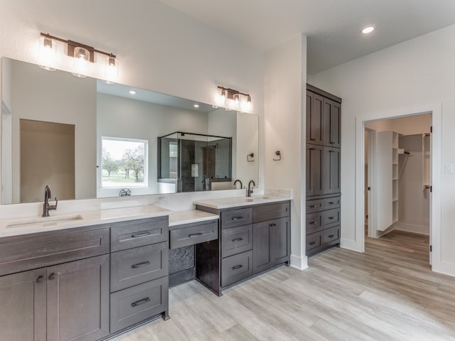 bathroom with hardwood / wood-style flooring and double vanity