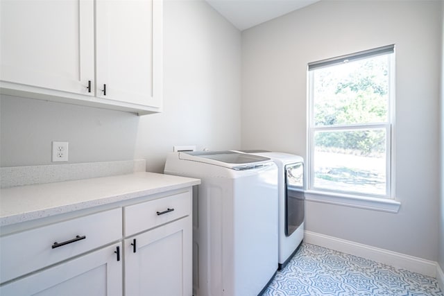 laundry area featuring cabinets, independent washer and dryer, and light tile patterned floors