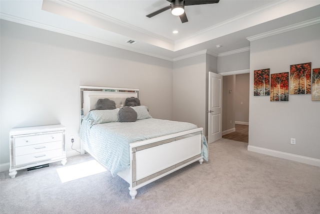 carpeted bedroom featuring a tray ceiling, ceiling fan, and ornamental molding