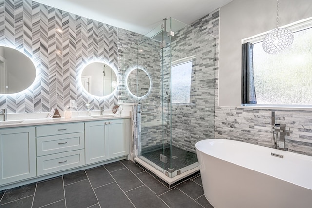 bathroom featuring vanity, tile patterned floors, tile walls, and a healthy amount of sunlight