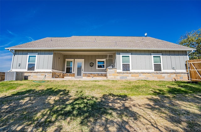 rear view of house featuring a lawn and a porch