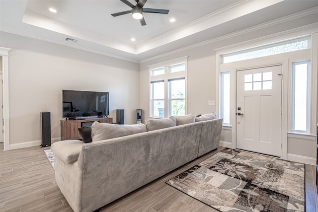 living room featuring ceiling fan, crown molding, and a tray ceiling