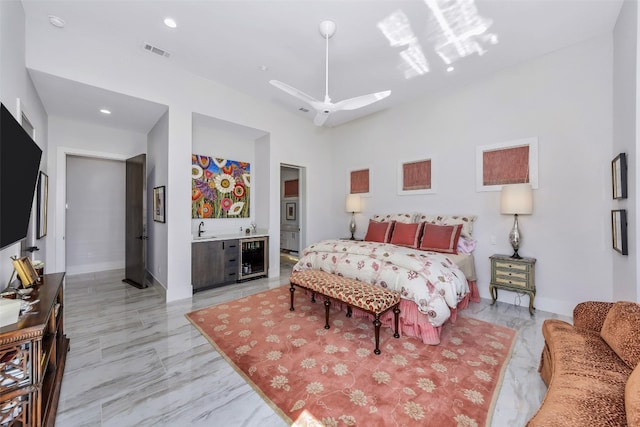 tiled bedroom featuring ceiling fan, sink, a towering ceiling, ensuite bathroom, and wine cooler