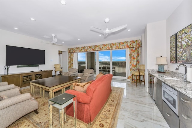 tiled living room featuring ceiling fan and sink