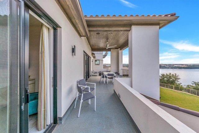 balcony with a water view and ceiling fan