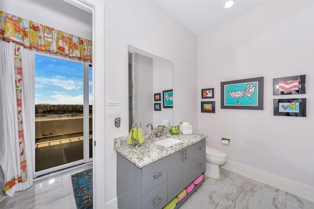 bathroom featuring toilet, vanity with extensive cabinet space, and tile floors