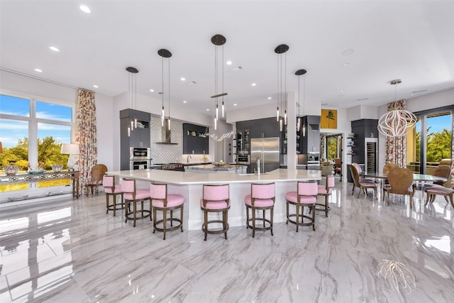 kitchen with built in fridge, backsplash, a healthy amount of sunlight, and light tile flooring