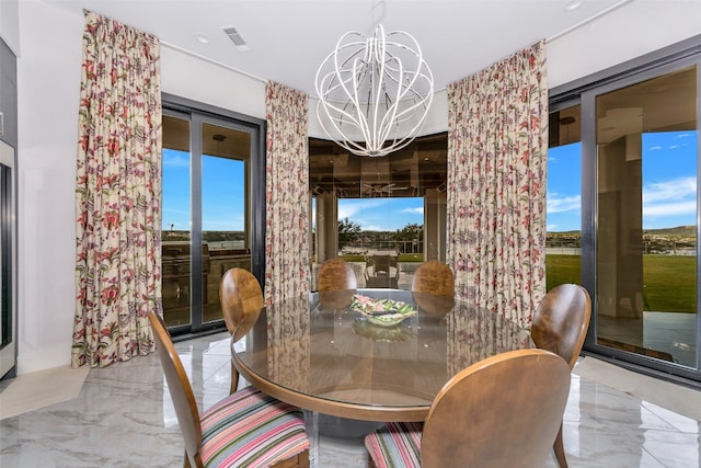 dining area featuring light tile floors and an inviting chandelier