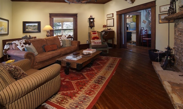 living room with crown molding, a fireplace, and dark hardwood / wood-style flooring