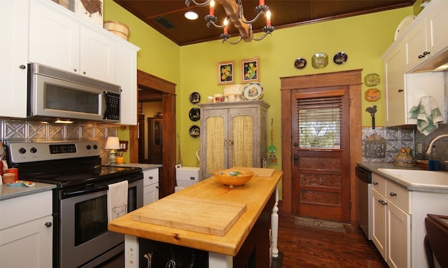 kitchen featuring sink, a chandelier, stainless steel appliances, tasteful backsplash, and white cabinetry