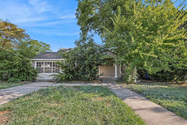 view of property hidden behind natural elements with a front yard