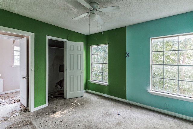 unfurnished bedroom featuring ceiling fan, light colored carpet, a textured ceiling, and a closet