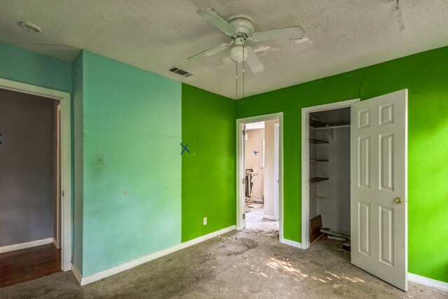 unfurnished bedroom featuring ceiling fan, a textured ceiling, a closet, and a spacious closet