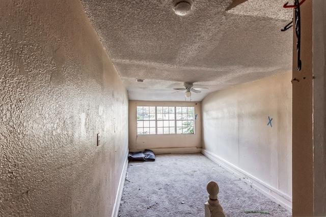 unfurnished room with a textured ceiling, carpet, and ceiling fan