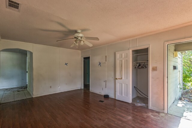 unfurnished bedroom featuring a textured ceiling, ceiling fan, and dark wood-type flooring