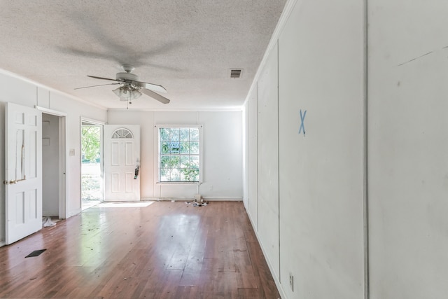 interior space featuring ornamental molding, wood-type flooring, ceiling fan, and a textured ceiling