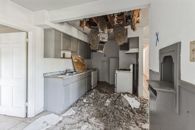 kitchen with gray cabinets, white range oven, and sink