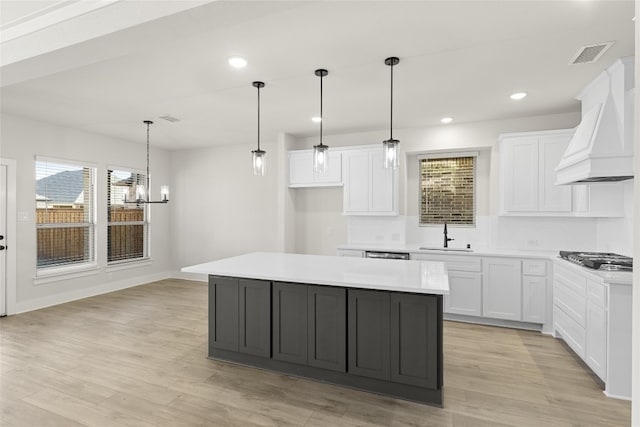 kitchen featuring a kitchen island, white cabinetry, and custom exhaust hood