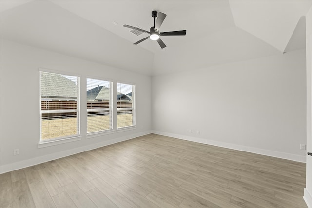 spare room with plenty of natural light, vaulted ceiling, light hardwood / wood-style floors, and ceiling fan