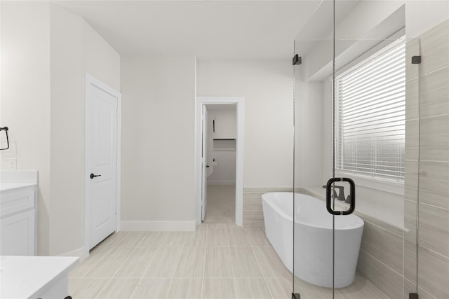 bathroom with a tub, tile floors, and vanity