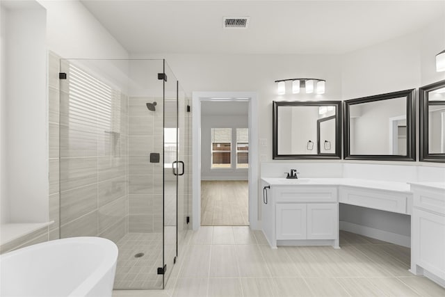 bathroom featuring vanity with extensive cabinet space, plus walk in shower, and tile floors