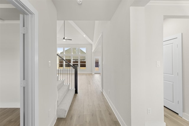 hall with light hardwood / wood-style floors and vaulted ceiling